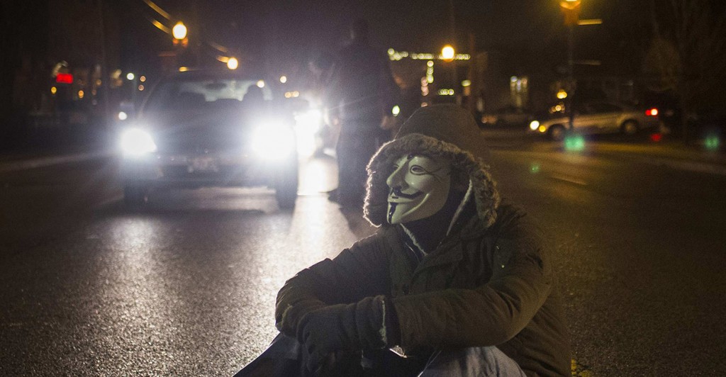 An activist, wearing a Guy Fawkes mask, blocks traffic while protesting outside the police station in Ferguson. (Photo: REUTERS/Adrees Latif/Newscom)