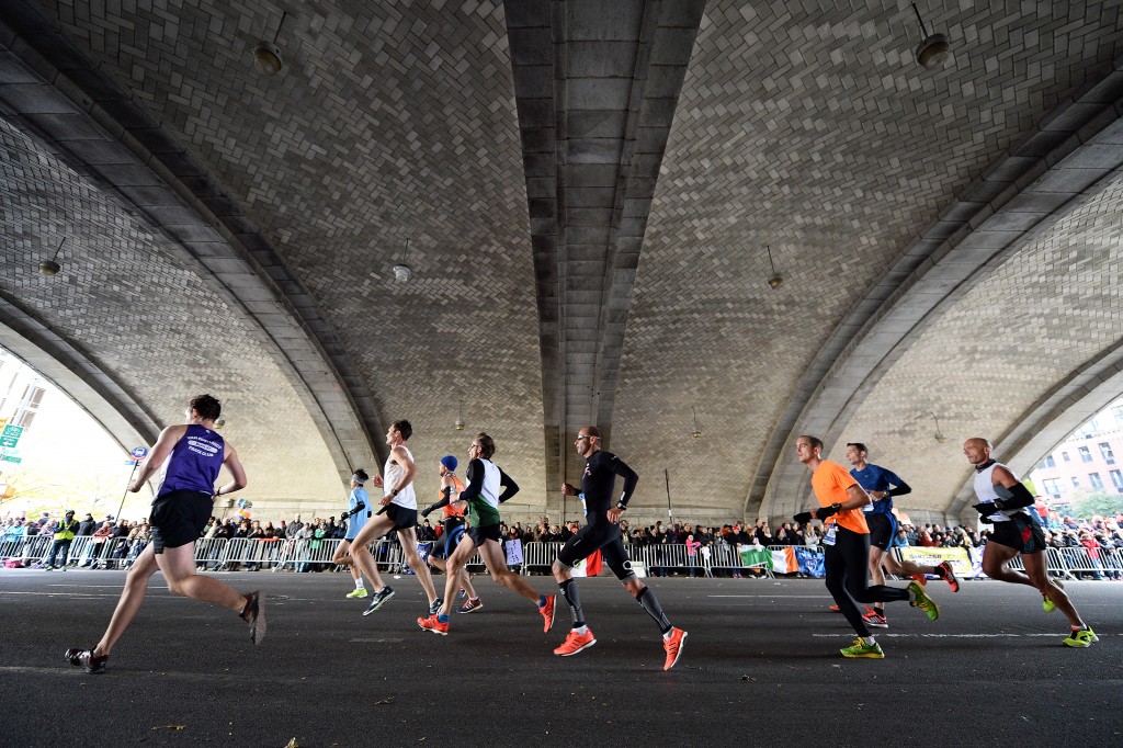 Runners pass in front of cheering crowds under the Ed Koch Queens Borough Bridge at mile 16. (Photo: Anthony Behar/Newscom)