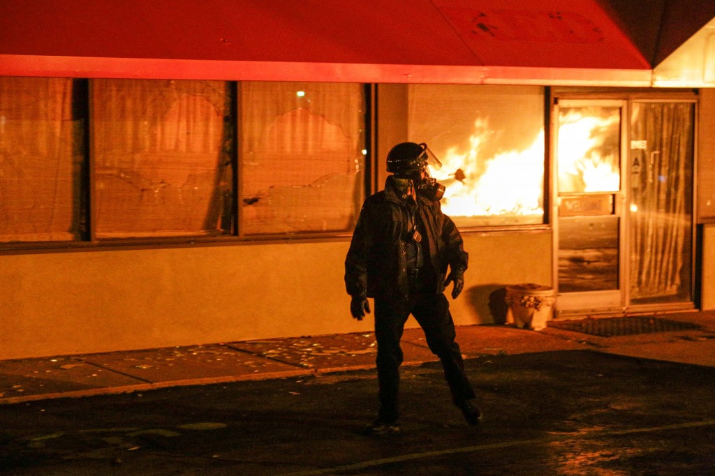 Firemen in Ferguson, Missouri work to extinguish one of four neighboring buildings that were looted and burned on South Florissant Road