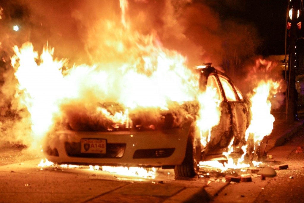 Angry protestors set police cars on fire in Ferguson. (Photo: Demotix/Newscom) 