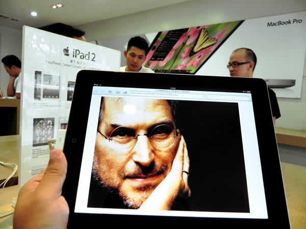 An iPad displays a picture of Apple CEO Steve Jobs