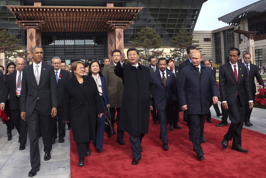 Chinese President Xi Jinping and President Barack Obama walk with Chilean President Michelle Bachelet, Russian President Vladimir Putin and Indonesian President Joko Widodo in Beijing. The group gathered to plant trees with other leaders and representatives from the Asia-Pacific Economic Cooperation Nov. 11. (Photo: UPI/Lan Hongguang/Pool/Newscom)