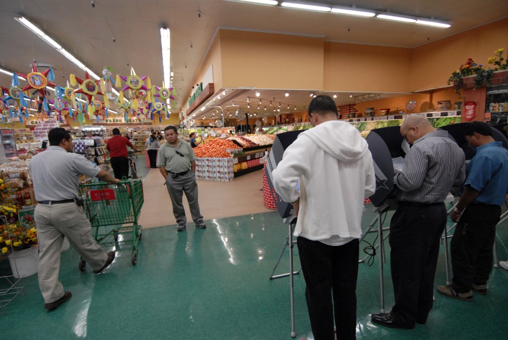 Voters cast their votes in the produce section of a Food Land grocery store. (Photo: Earl S. Cryer/Newscom)