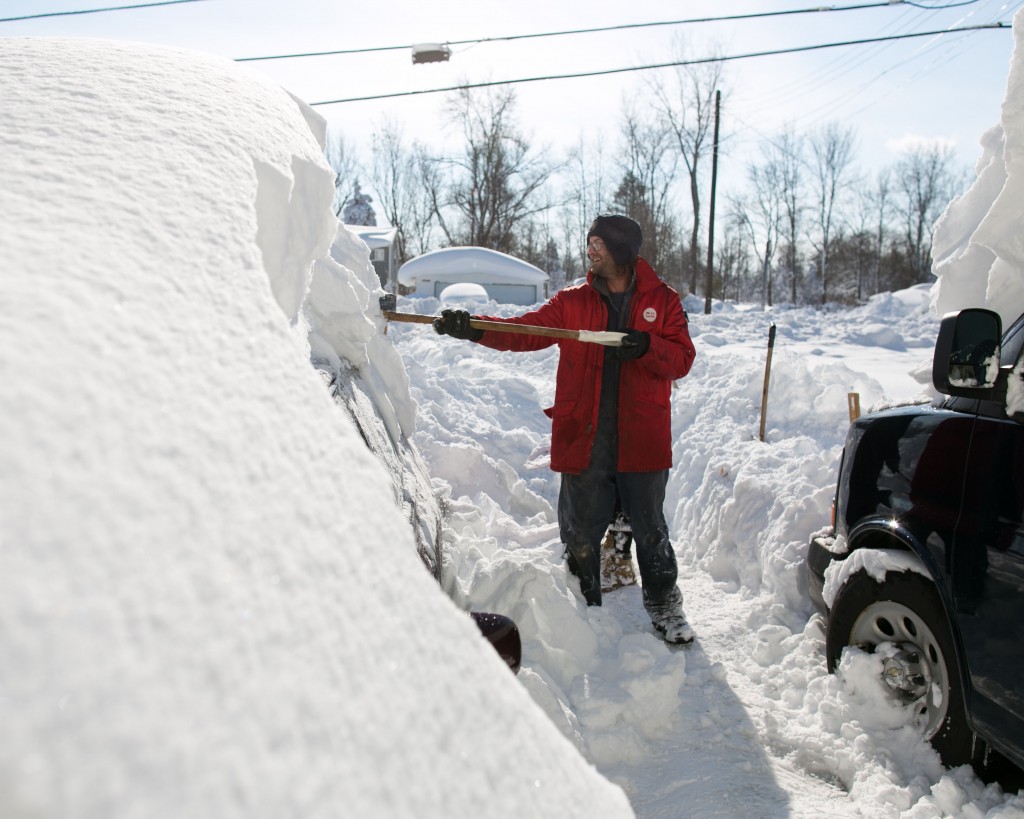 Dave Morris shovels snow from atop his car in Alden, New York. (Photo: Newscom)