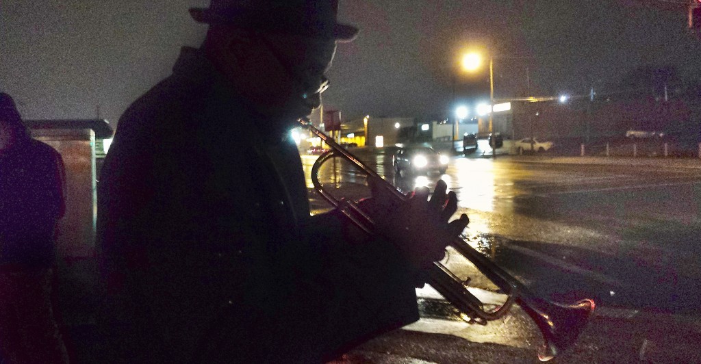 Eugene Gillis, 56, plays his melancholy jazz trumpet on West Florrisant Ave. in Ferguson, Mo. Gillis, a GM autoworker, says he's doing his part to ''bring down the temperature'' and calm frayed nerves. (Photo: Mitch Potter/Newscom)