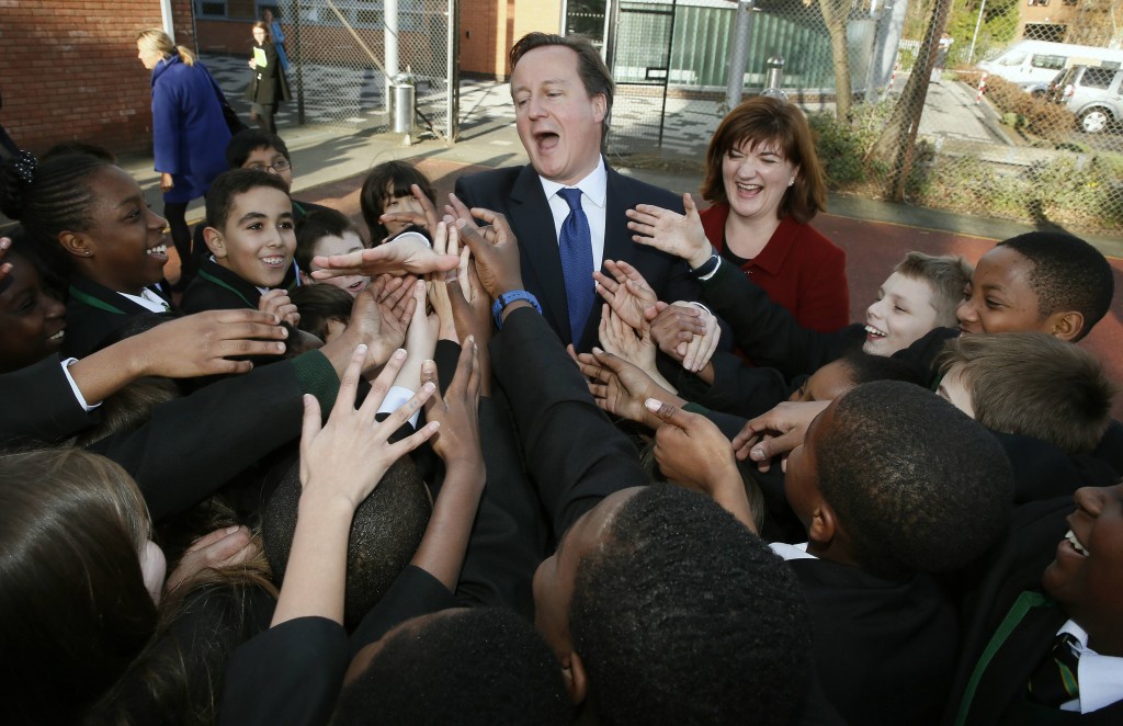 Britain's Prime Minister David Cameron shakes hands with year seven students at the Harris City Academy in south London. (Photo: Stefan Wermut/Newscom)