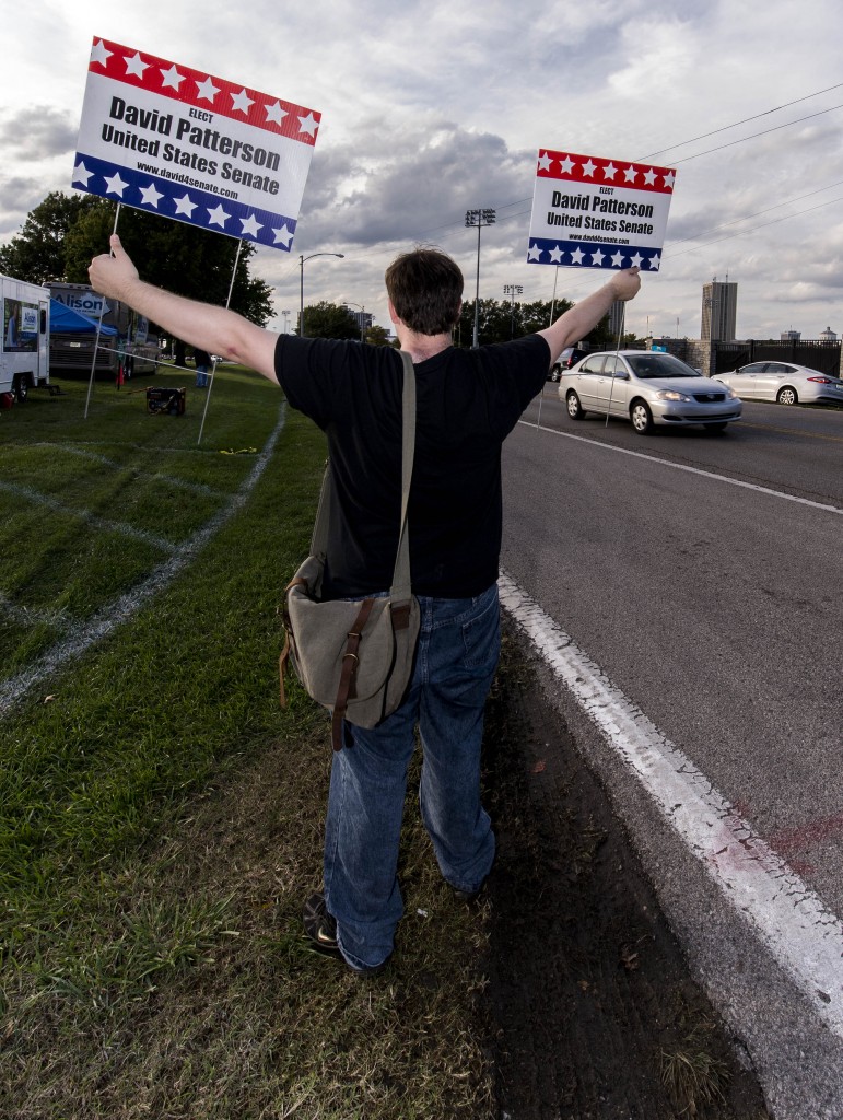 Warren Taylor holds a sign for Libertarian candidate David Patterson. (Photo: Newscom)