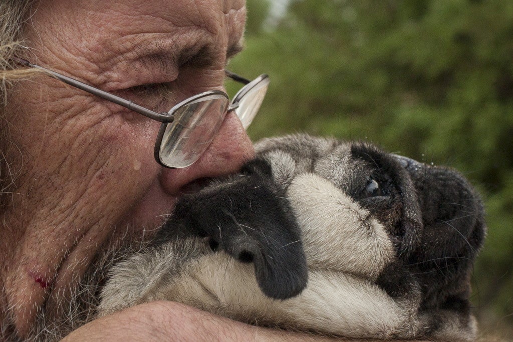 Hooper hugs his dog Toby on his property after seeing the damage of the northern California fire that’s claimed one life and burned at least 400 homes to the ground. (Photo: REUTERS/David Ryder/Newscom)