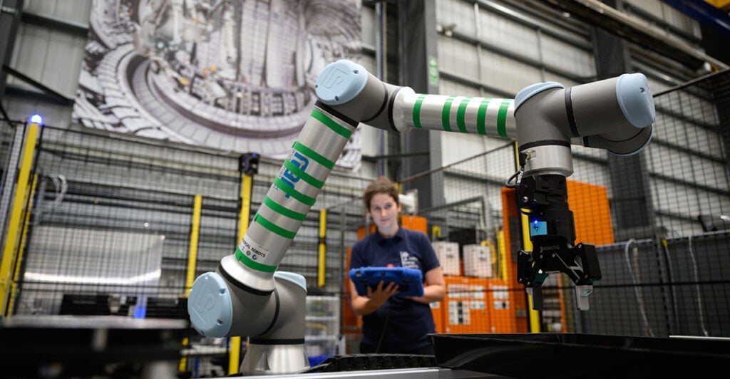 female technician takes notes under nuclear fusion reactor