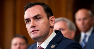 Congressman in a suit stands in front of his colleagues