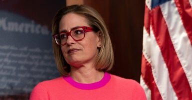 Kyrsten Sinema in front of an American flag.