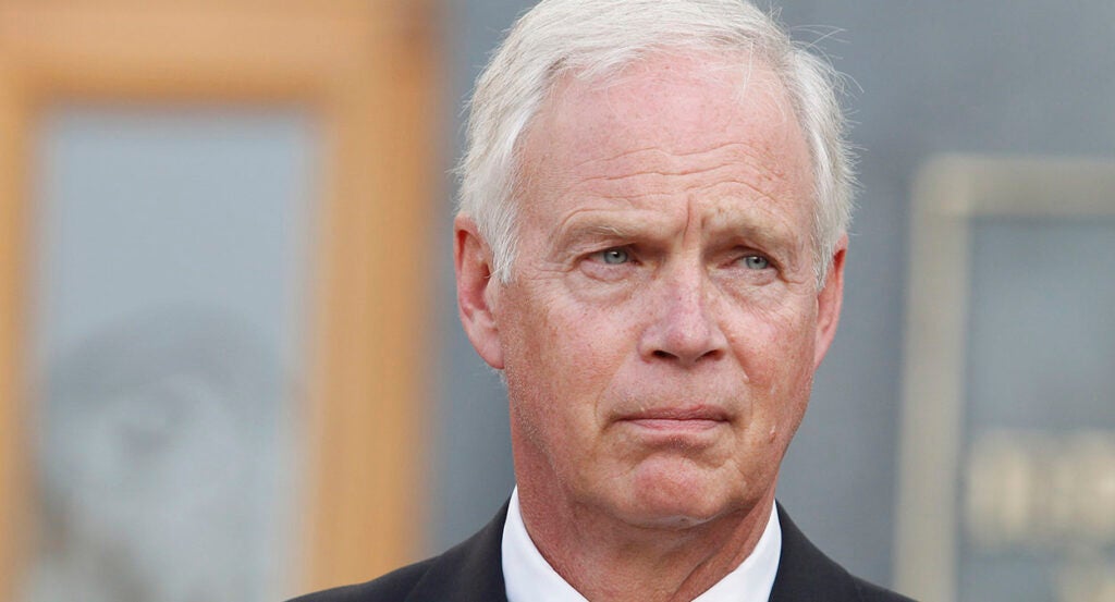 Elderly white man scowls in a suit and white hair