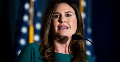 Sarah Huckabee Sanders in front of American flags