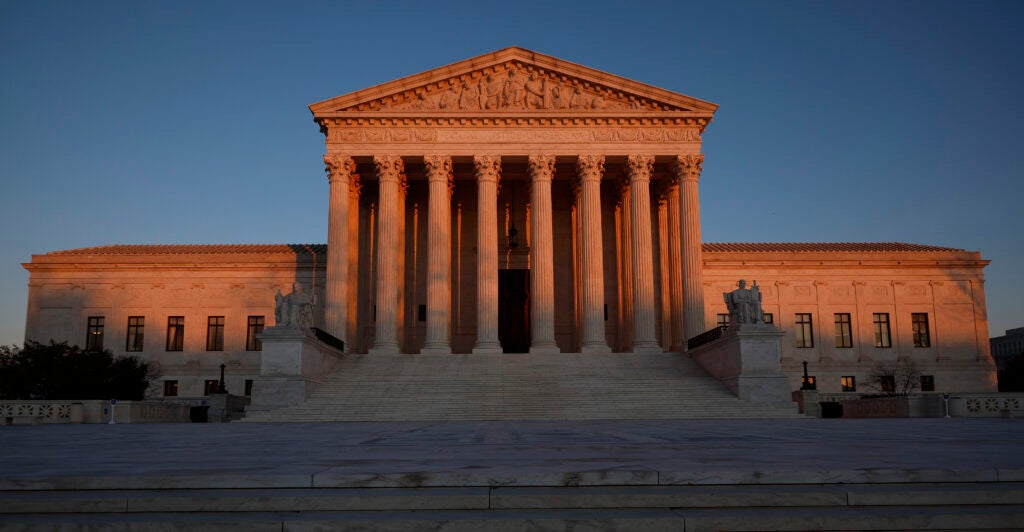 The Supreme Court building with the sun setting