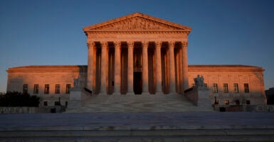 The Supreme Court building with the sun setting