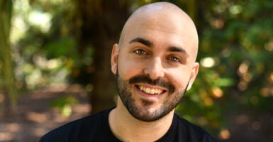 Matt Grech, a bald white Maltese man with a close-cropped black beard, smiles in a forest setting