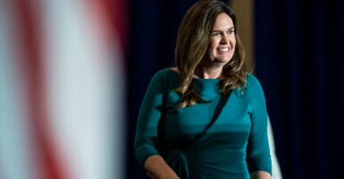 Sarah Huckabee Sanders smiles in a gray dress