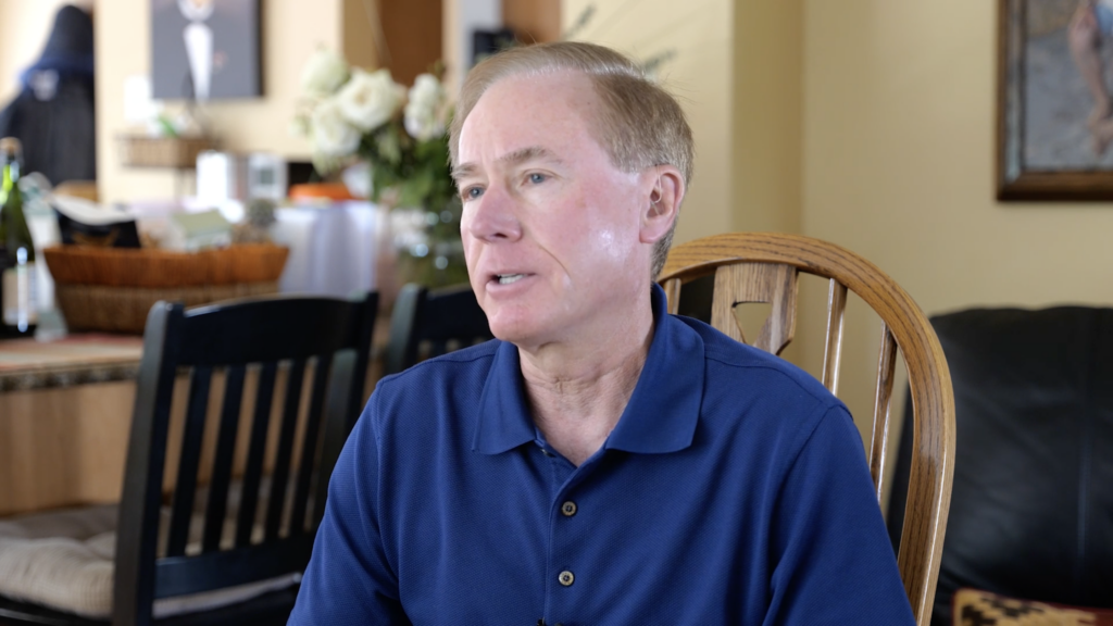 Middle-aged man in blue polo shirt speaks in Dead Name