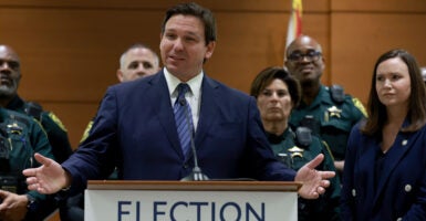 Ron DeSantis speaks at a podium in a suit