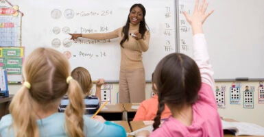 Black female teacher in front of a classroom