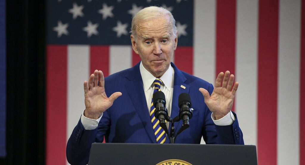 Joe Biden in a suit in front of an American flag