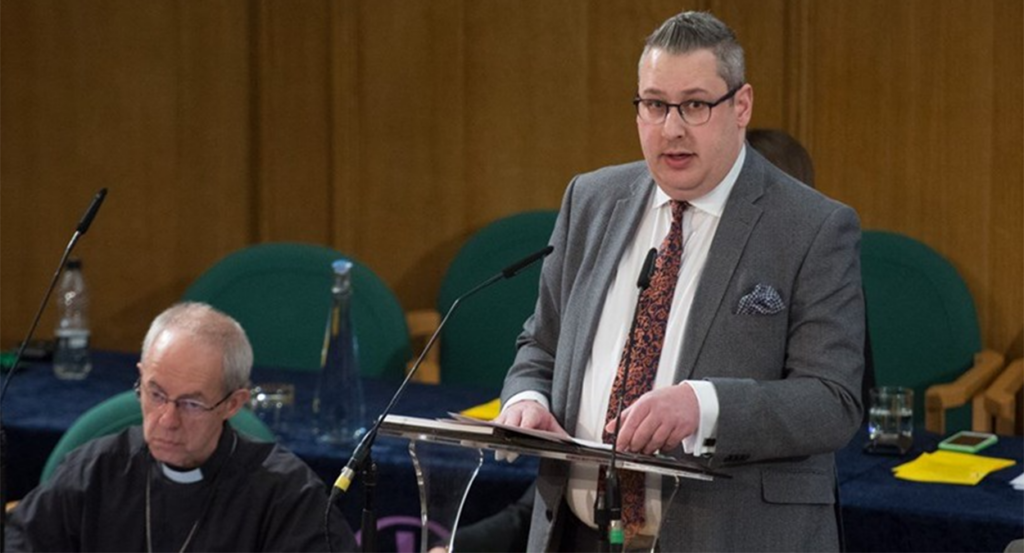 Sam Margrave in a suit standing by Justin Welby