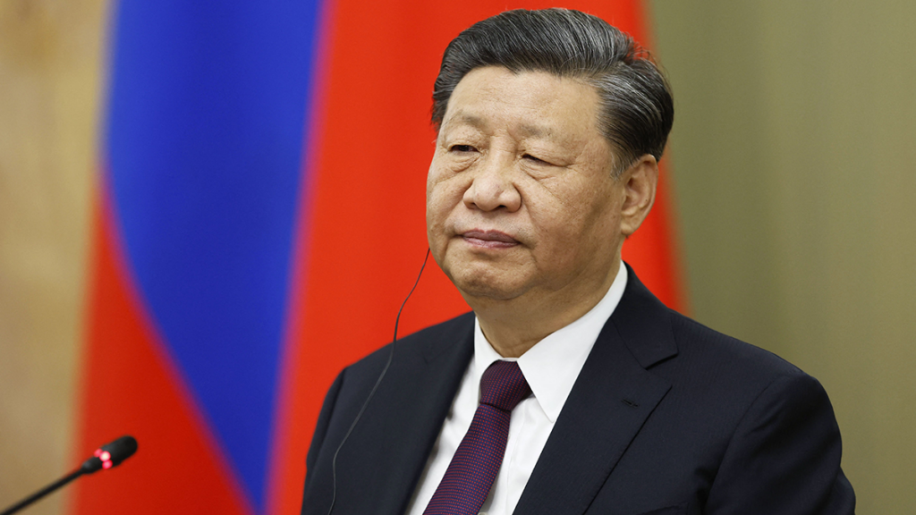 Xi Jinping in a suit in front of a red background