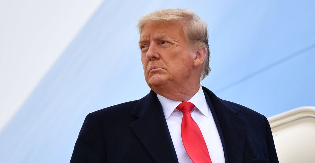 Donald Trump in a suit in front of Air Force One