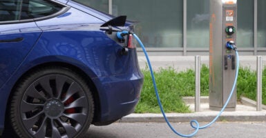 A Tesla electric vehicle is charged at a public charging station.