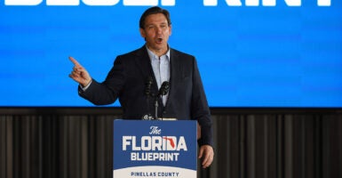 Ron DeSantis speaks at a podium with 