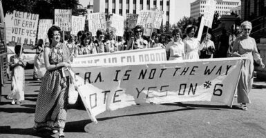 Women march in 1976 holding a sign reading 