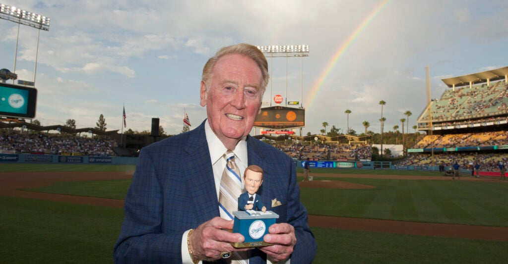 Vin Scully stands with a trophy at Dodgers Stadium