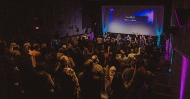 Christians gather for worship in a movie theater at The Pines Church