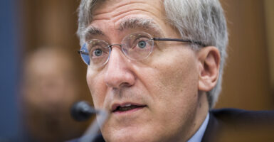 Robert P. George testifies in a suit wearing glasses