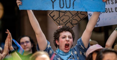 Female pro-transgender protester screams while holding sign