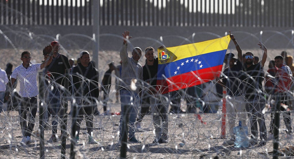 Venezuelan migrants at the border hold a Venezuelan flag