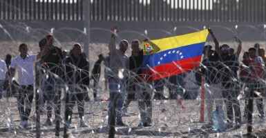 Venezuelan migrants at the border hold a Venezuelan flag