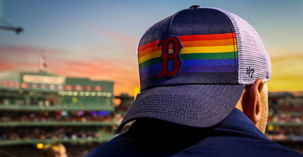 Boston Red Sox fan at a game with LGBTQ pride hat