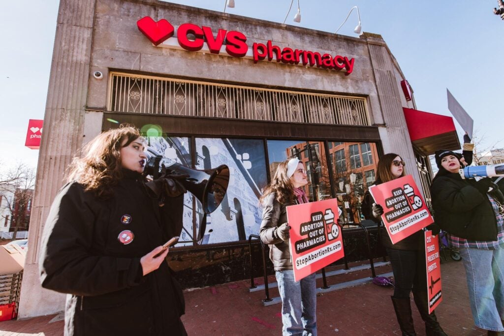 Elise Ketch protests outside CVS with members of PAAU against the pharmacy's decision to sell abortion drugs. Photo by Mark Story. 