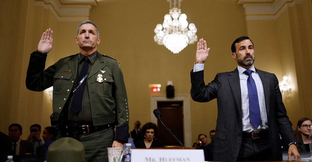 Benjamine Huffman and Blas Nuñez-Neto hold up their right hands as they are sworn in before giving testimony before members of Congress.