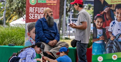 Refugee speaks in front of a Refugee Services sign