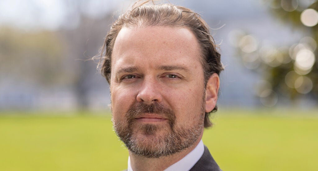 Scott Parkinson in a suit with a green background