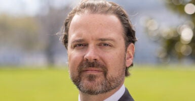 Scott Parkinson in a suit with a green background