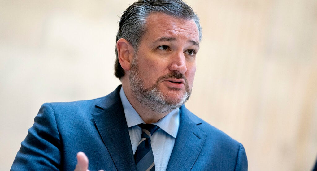 Sen. Ted Cruz gestures while wearing a blue suit