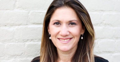 Tina Ramirez smiling in front of a brick wall