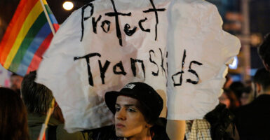 Activist marches with a sign reading 