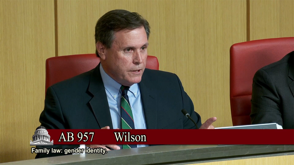 Scott Wilk in a suit speaks at a desk