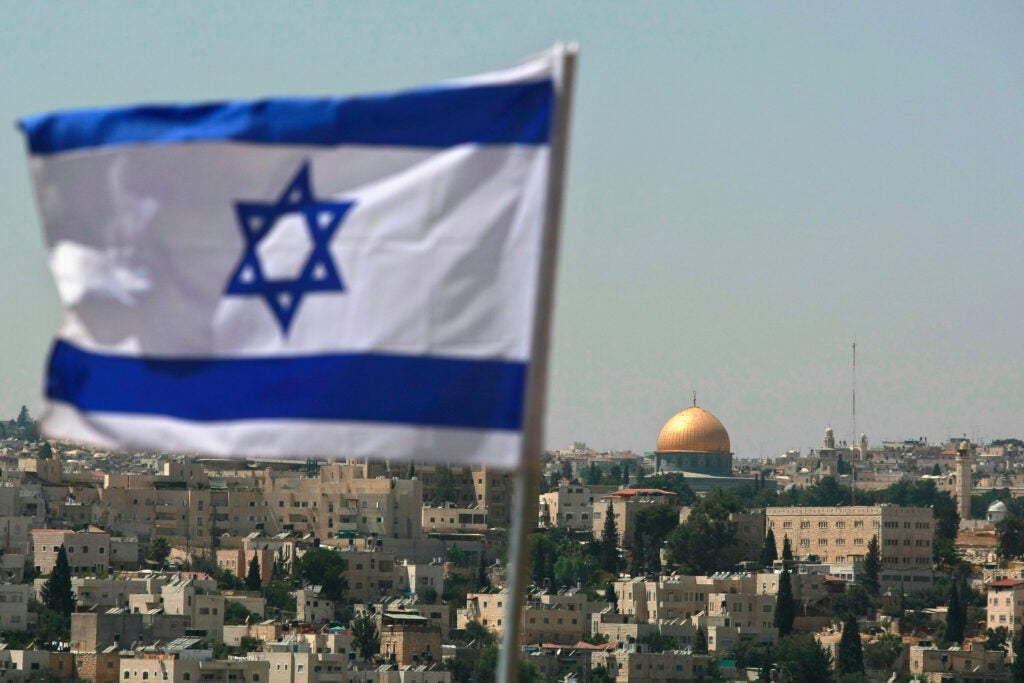 JERUSALEM - AUGUST 18:  An Israeli flag flies from the Kidmat Zion Jewish settlement community on the outskirts of the Arab village of Abu Dis, where the Old City with its golden Dome of the Rock Islamic shrine is seen in the background, August 18, 2008 in East Jerusalem, Israel. The settlement, a stand-alone apartment building which houses a number of families, is a former Arab home purchased by the Ateret Cohanim organization which is dedicated to expanding Jewish settlement in East Jerusalem, the half of the city that Israel captured from Jordan in the 1967 Six Day War.  (Photo by David Silverman/Getty Images)