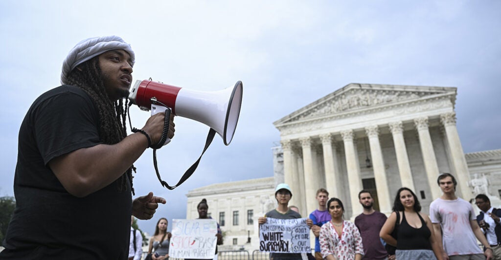 Person shouts through microphone outside the Supreme Court