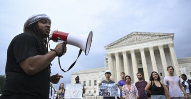 Person shouts through microphone outside the Supreme Court